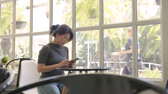 attractive asian mature adult female relax casual hand use smartphone alt