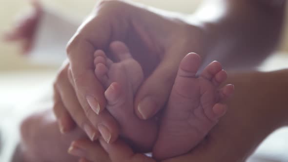 Newborn baby boy and his mother at home. Close-up portrait of the infant alt