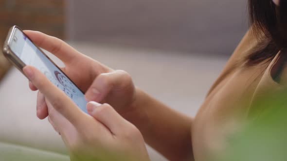 Close up hands young Asian businesswoman holding typing mobile phone.