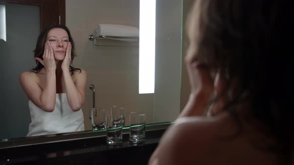 Middleaged Woman is Doing Rejuvenating Massage for Face Applying Cream on Skin alt