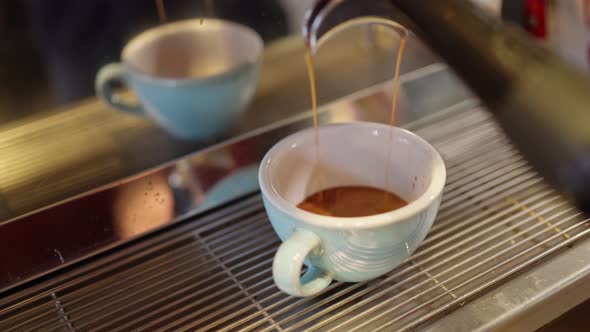 a Light Blue Mug Stands in a Professional Coffee Machine and a Beautiful Hot Fragrant Espresso alt