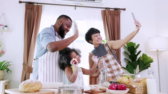 Happy African American family take a selfie by smartphone at home in the kitchen
