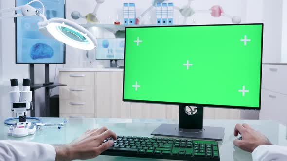 Male Doctor Hands Working on Mock-up Green Screen Computer alt