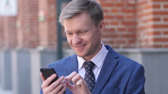 Portrait of Businessman Busy Using Smartphone alt