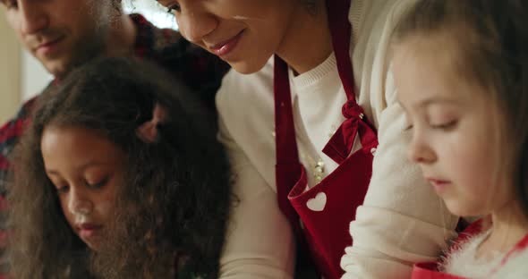 Tilt down video shows of family baking cookies for Christmas alt