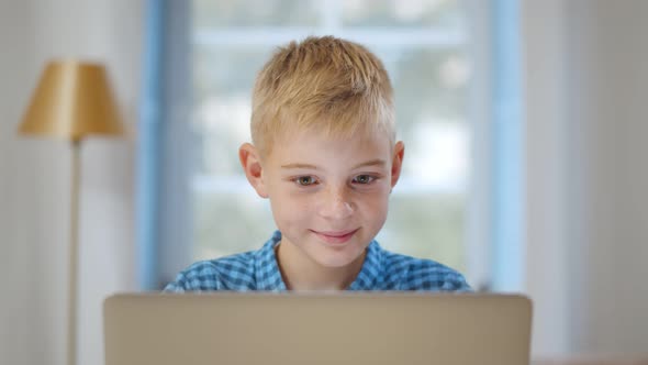 Portrait of Caucasian Preteen Boy Using Laptop at Home alt