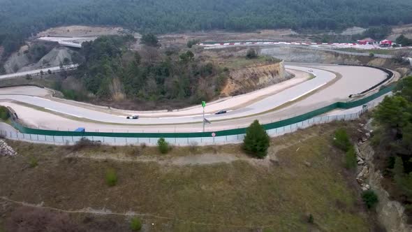 aerial shot of sports cars in a section of a racing circuit alt