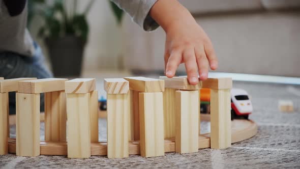 Child Play Build Wooden Railroad Starts an Electronic Steam Locomotive Sitting on the Floor at Home alt