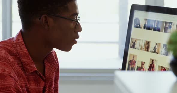Side view of African American male graphic designer working at desk in office 4k