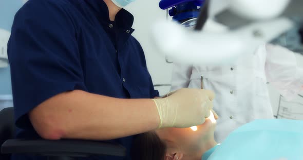 The Dentist Examines the Patient's Oral Cavity Using a Dental Mirror alt