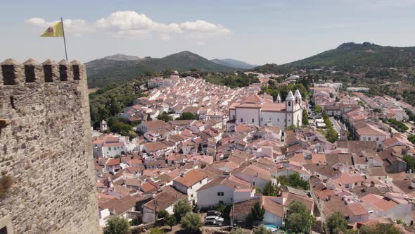 Aerial pullback from romantic village revealing Old Castle, Castelo de Vide - Portugal alt