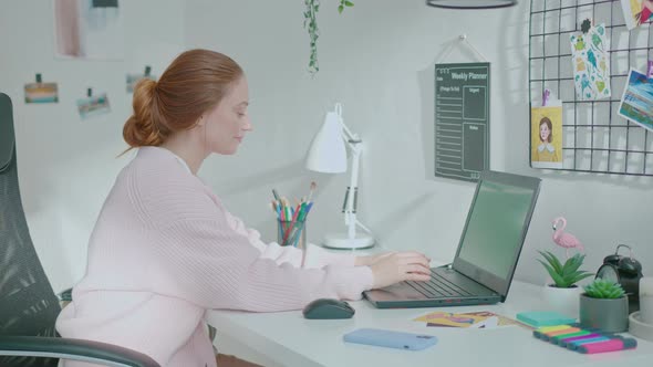 Female Designer Using Laptop at Home and Answer Phone alt