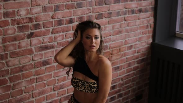 Sexy Woman in Underwear Dancing Against Brick Wall