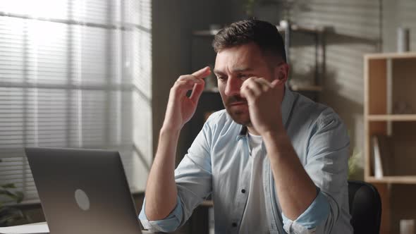 Stressed Young Male Employee Manager Rubbing Forehead Thinking of Difficult Problem Solution Feeling alt