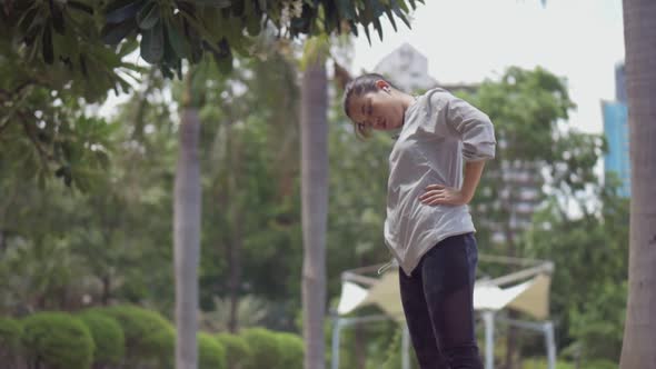 Attractive caucasian Asian girl warming up to run.