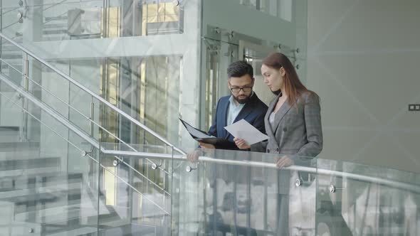 Man and a Woman in Suits Are Standing in a Modern High-tech Building