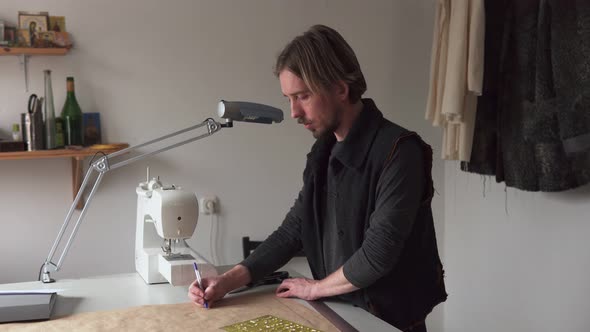 Man Designer Drawing Creative Clothing Pattern While Working in Workshop