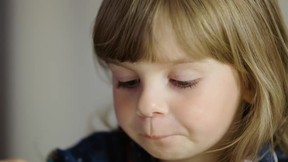 Portrait of a Little Girl Eating Pasta and Smiling