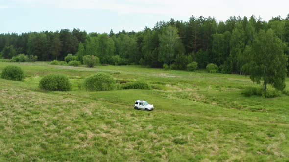 Aerial View of a Car Driving in Nature Near the River alt