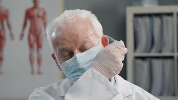 Elderly Doctor Wearing Medical Mask and Gloves alt