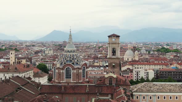Church tower of Turin with colorful rooftops, aerial low altitude flying view alt