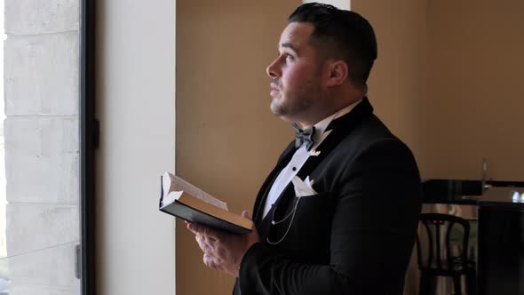 Jewish man in elegant outfit rise his eyes to God, praying, reading Holy Scripture alt