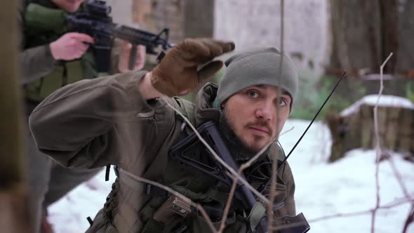 Portrait of Serious Soldier Gesturing Go to Group Taking Cover in Ruined City alt