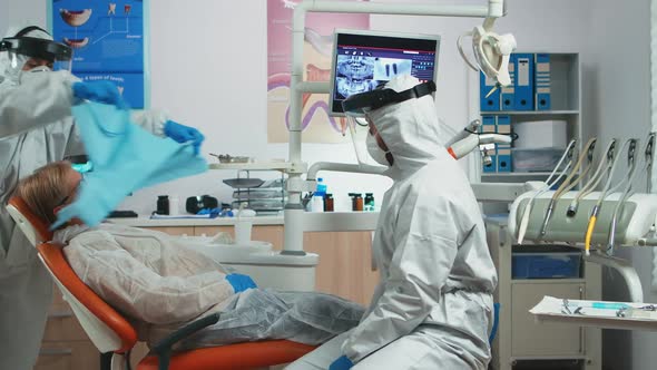 Dentist Doctor with Protection Equipment Talking with Old Patient alt