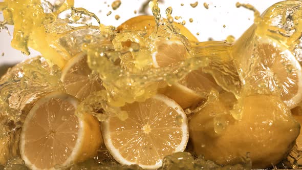 Slow Motion Shot of Lemon Juice Splashing Through Lemon Slices alt