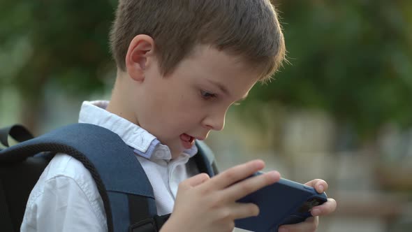 Closeup of a Schoolboy Playing His Favorite Games on His Smartphone After a Hard Day at School