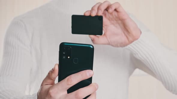 Young Man Uses Smartphone to Scan QR Code on Cold Crypto Wallet for Transaction alt