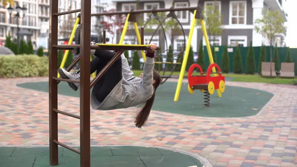 Little Girl Having Fun Playing on Monkey Bars alt