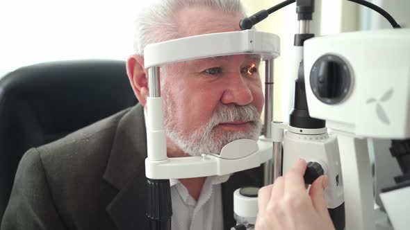 Examination of Elderly Man with Slit Lamp alt