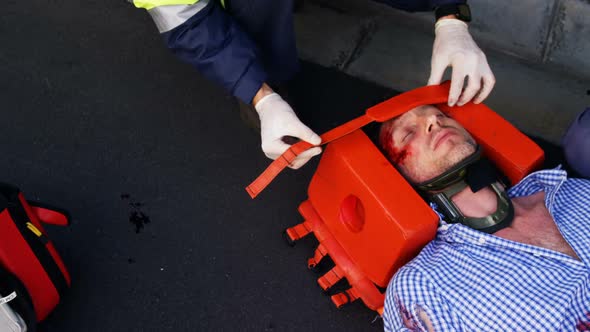 Emergency medical technician protecting the head of his wounded person alt