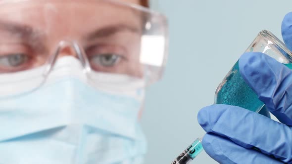 Scientist in a Protective Medical Surgical Mask and Blue Nitrile Gloves Holding Flu Measles