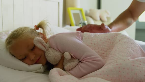 Father waking up his sleeping daughter in bedroom at home 4k alt