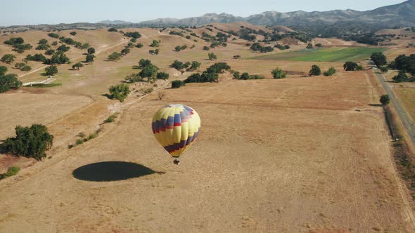 Aerial  Overhead View of Descending Hot Air Balloon with Happy People Tourists alt