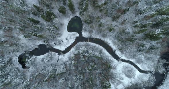 Water Flowing To River From Springs in Snowy Winter Forest Aerial View alt