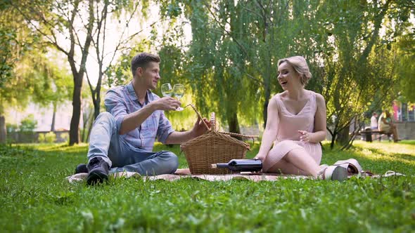 Happy Couple Unpacking Wine Bottle from Picnic Basket, Wonderful Rest Together alt