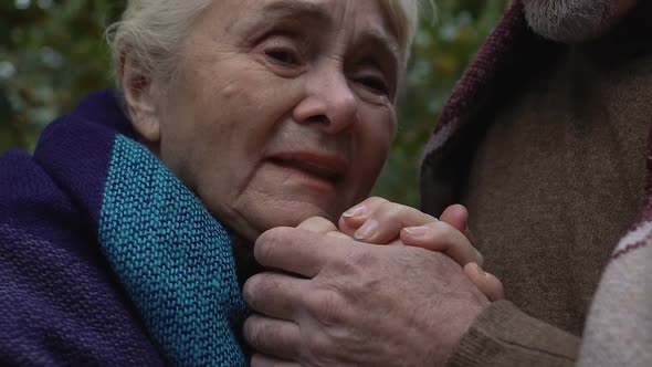 Old Woman Crying Holding Hands of Spouse, Social Insecurity of Retired People