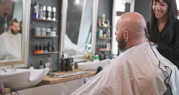 A Female Barber Turned to Camera Brushes Bearded Man's Smoothly Shaved Head Without Hair Who is alt