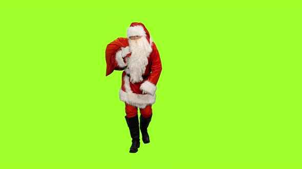 Santa Claus Carrying Christmas Gifts in Sack on Green Background