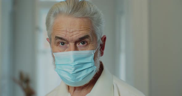 Portrait of Senior Man in Medical Mask Looking at Camera alt
