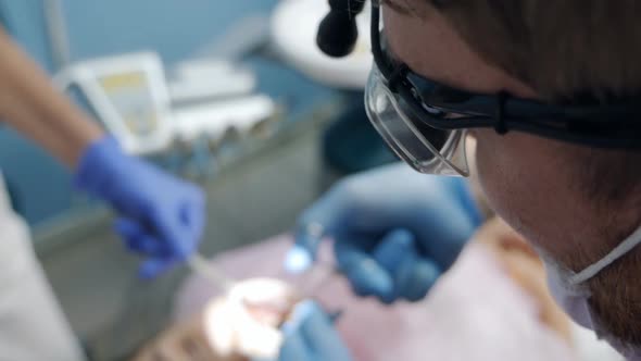 A Dental Surgeon Works with a Patient in a Modern Dental Clinic