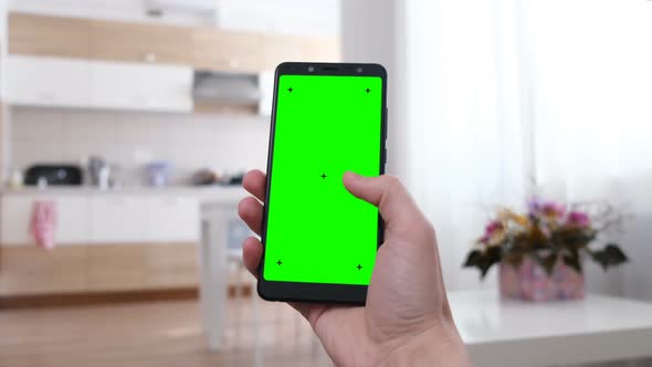 Man at Home Using Smartphone with Green Screen. Point of View Camera Shot