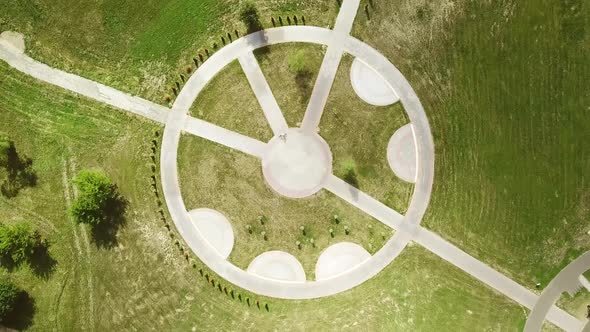 Top view of a bicycle woman riding a bicycle on a circular road in a city park. alt