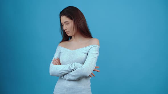 The Unwell Sad Young Woman with Her Hands in the Middle Looks to the Left and Points Her Finger to alt