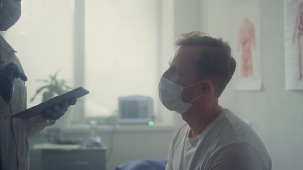 Man Patient Listening Doctor Advices Sitting in Modern Hospital Office Close Up alt