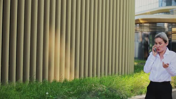 Smiling Female Professional Talking on Smart Phone Outside Office Building alt