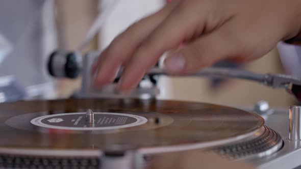 Close-up of Man's Hand Opens Turntable and Sets Pickup on Vinyl Record